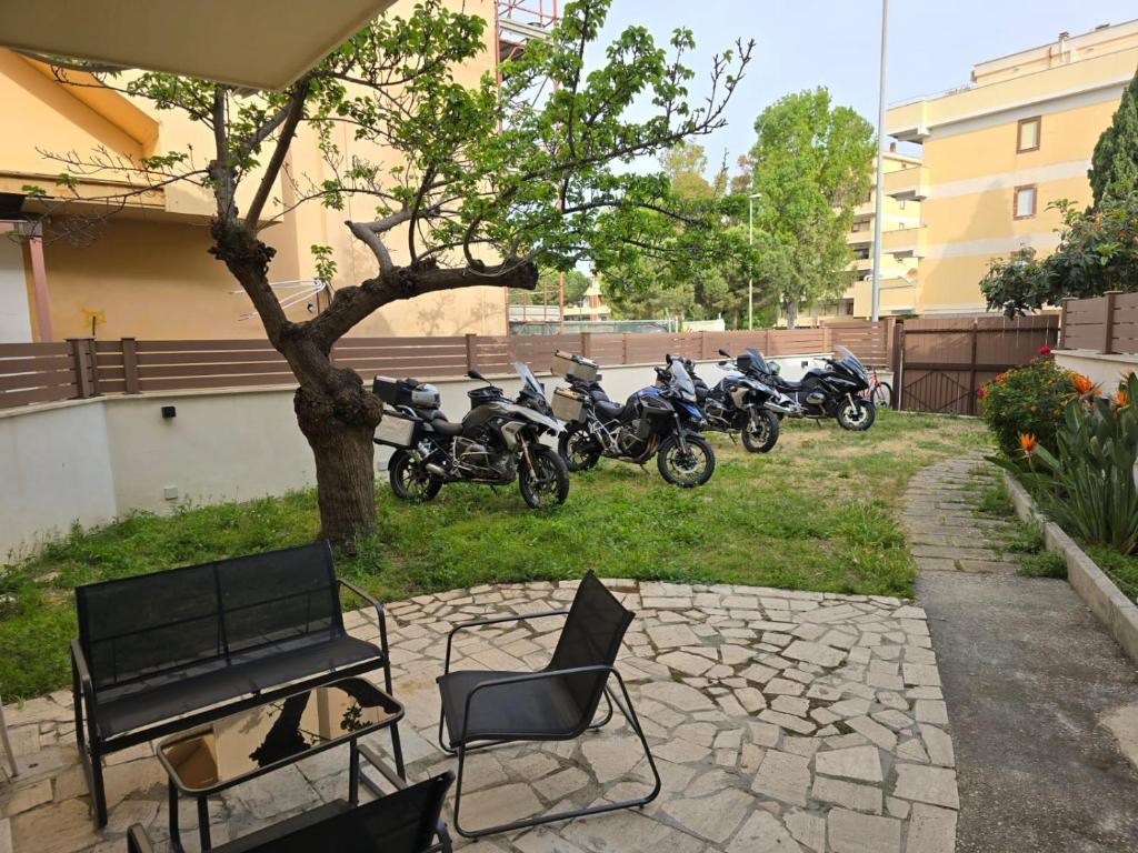 a row of motorcycles parked in a yard with a bench at I MORI Alloggio turistico in Civitavecchia