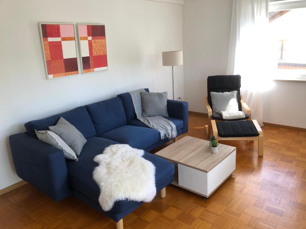 een woonkamer met een blauwe bank en een stoel bij Ferienwohnung Sonnenblick in Amerang