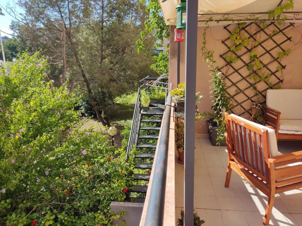 een veranda met een bank en een tuin bij Iknos House in Monserrato