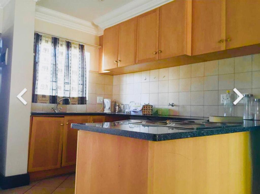 a kitchen with wooden cabinets and a counter top at Classic Loft in Pretoria