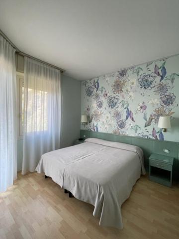a bedroom with a bed and a floral wall at Sole Mare in Ventimiglia