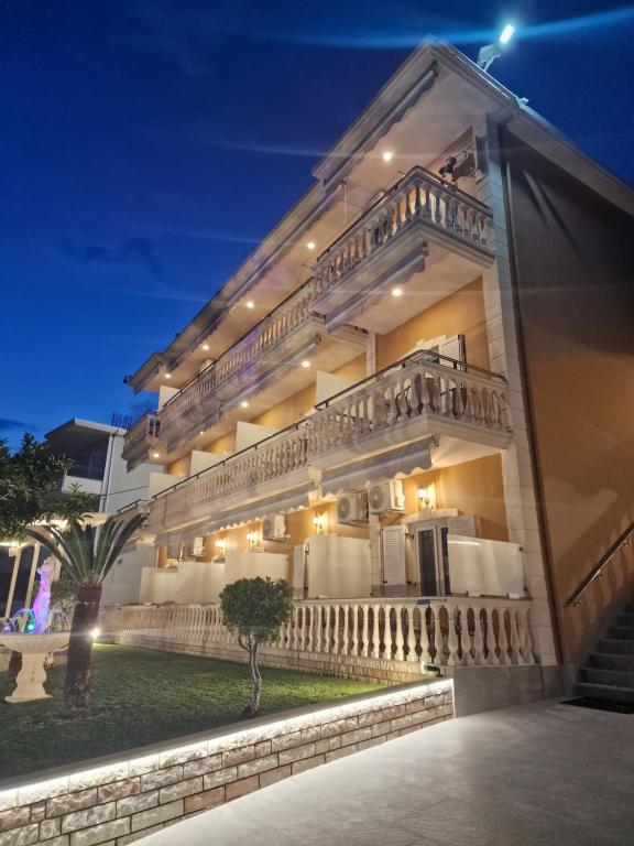 帕爾加的住宿－愛奧尼亞海濱瓦爾多斯酒店，一座在夜间有楼梯的大建筑
