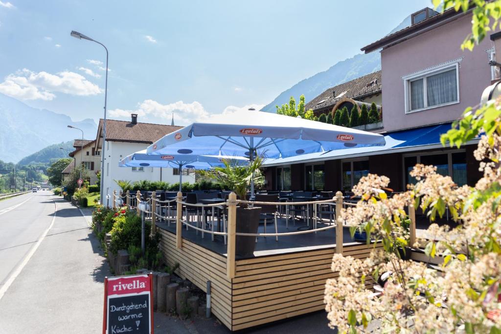 ein Restaurant mit blauen Sonnenschirmen an der Straßenseite in der Unterkunft Hotel Schiffahrt in Mols