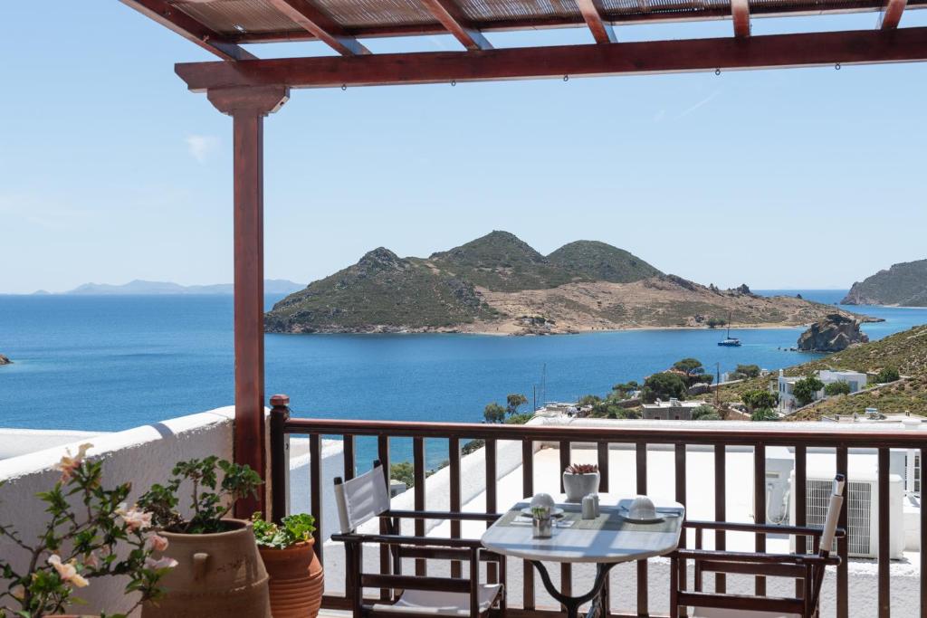 a table on a balcony with a view of the ocean at Golden Sun Hotel Patmos in Patmos