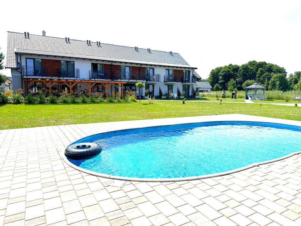 a swimming pool with a tire in front of a house at Pokoje Gościnne Kameralnie in Jantar