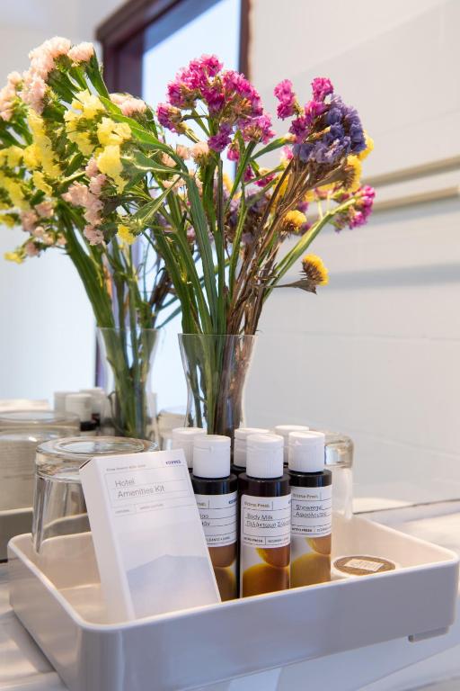 a tray with three bottles of essential oils and flowers at Golden Sun Hotel Patmos in Patmos