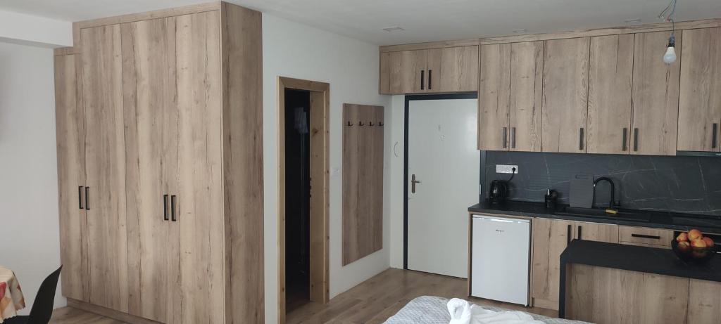 a kitchen with wooden cabinets in a room at Apartmán Orchidea in Stará Ľubovňa
