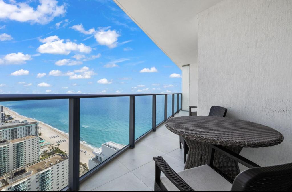 a balcony with a table and a view of the ocean at Lyfe Oceanview Resort Luxury 2 Bedroom Unit in Hollywood