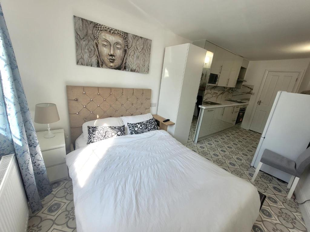a bedroom with a bed and a painting on the wall at Annexe Studio own entrance and parking in Ruislip