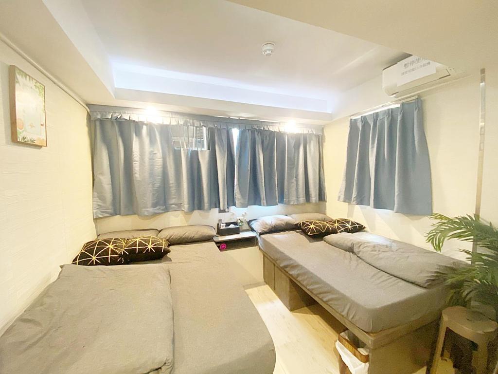 a room with two beds in front of a window at 榆樂旅館 YULOK Guesthouse in Hong Kong