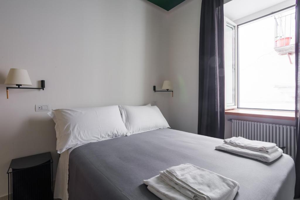 a bedroom with a bed with two towels on it at Weaver Suites By Dimorra in Naples