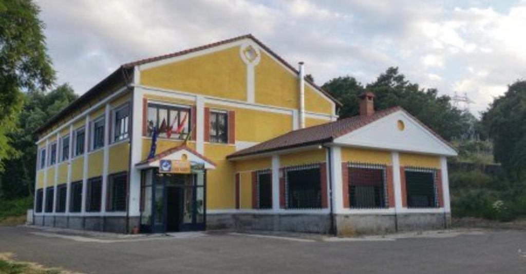 a yellow building with a basketball hoop on the front at Albergue de Guardo in Guardo