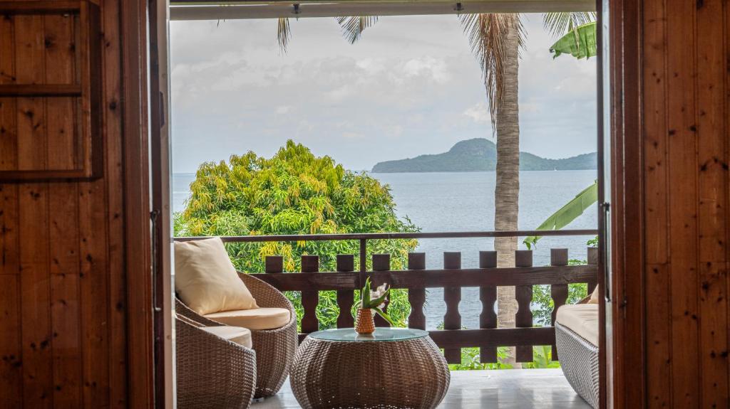 a room with a balcony with a view of the ocean at Jade hôtel and spa in Bandrélé