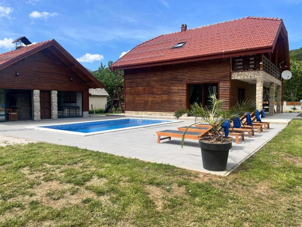una casa con piscina al lado de un edificio en Villa D-IKA en Brušane