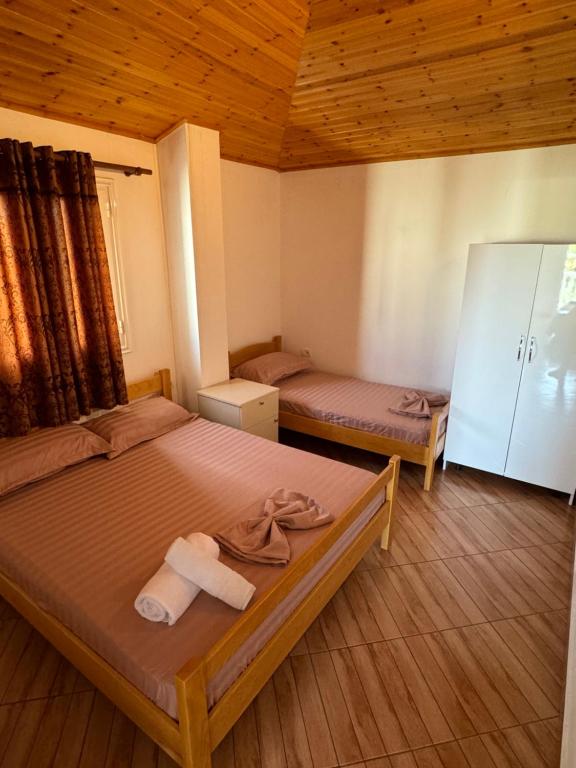 a bedroom with two beds with towels on them at Holiday House in Lezhë