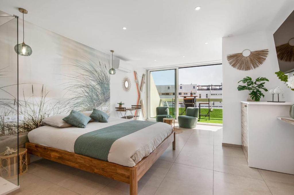 une chambre avec un grand lit et un balcon dans l'établissement LIBERTY Héliopolis, au Cap d'Agde