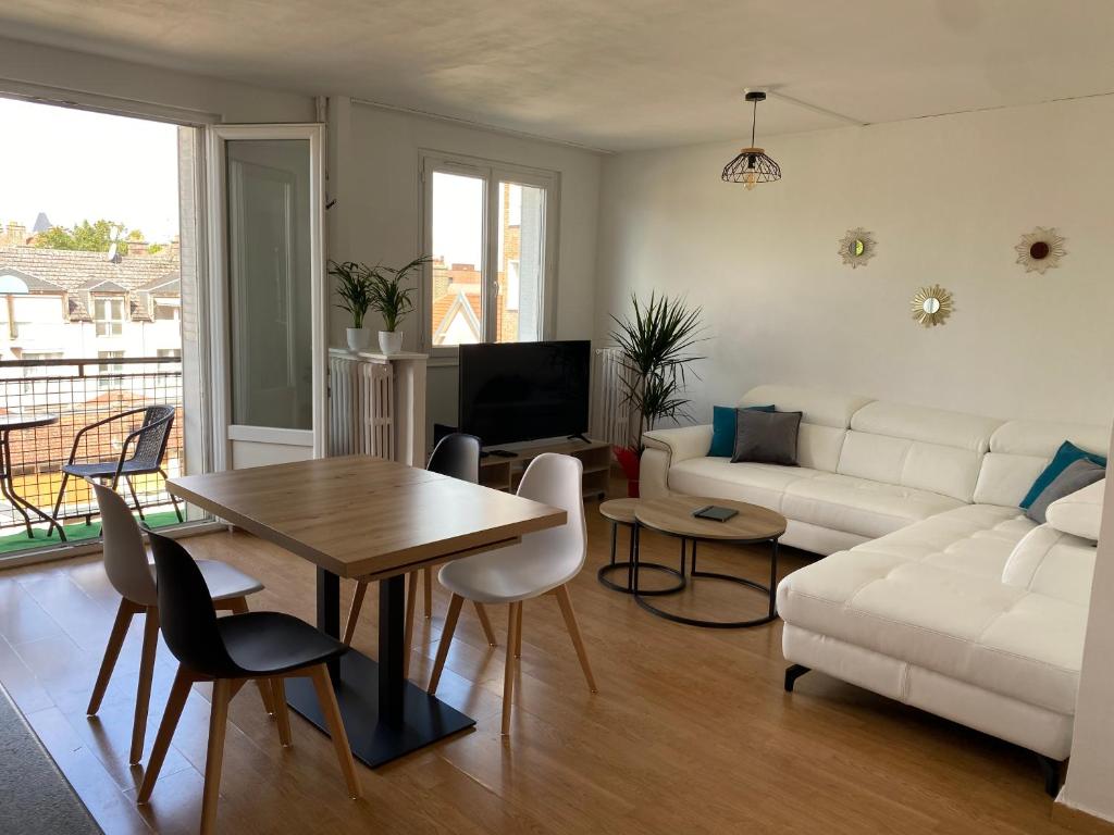 un salon avec un canapé blanc et une table dans l'établissement Chez Julien, à Troyes