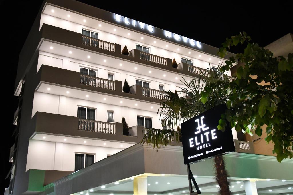 un bâtiment avec un panneau devant lui dans l'établissement Elite Hotel, à Golem