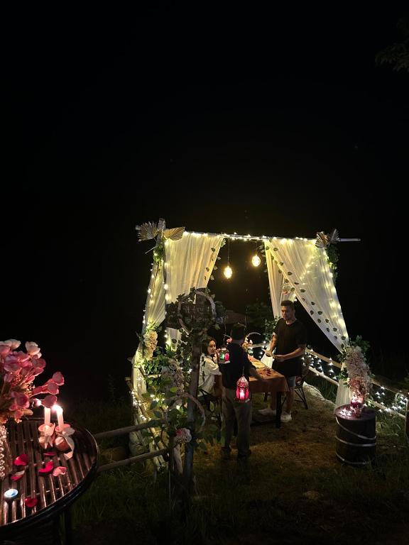 a group of people standing under a tent at night at Wild Adventure Resort - Sunset Point in Sauraha