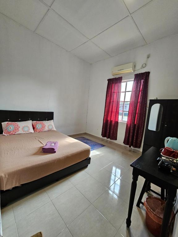 a bedroom with a bed and a table in it at Hotel Bajet Warisan Pekan in Pekan