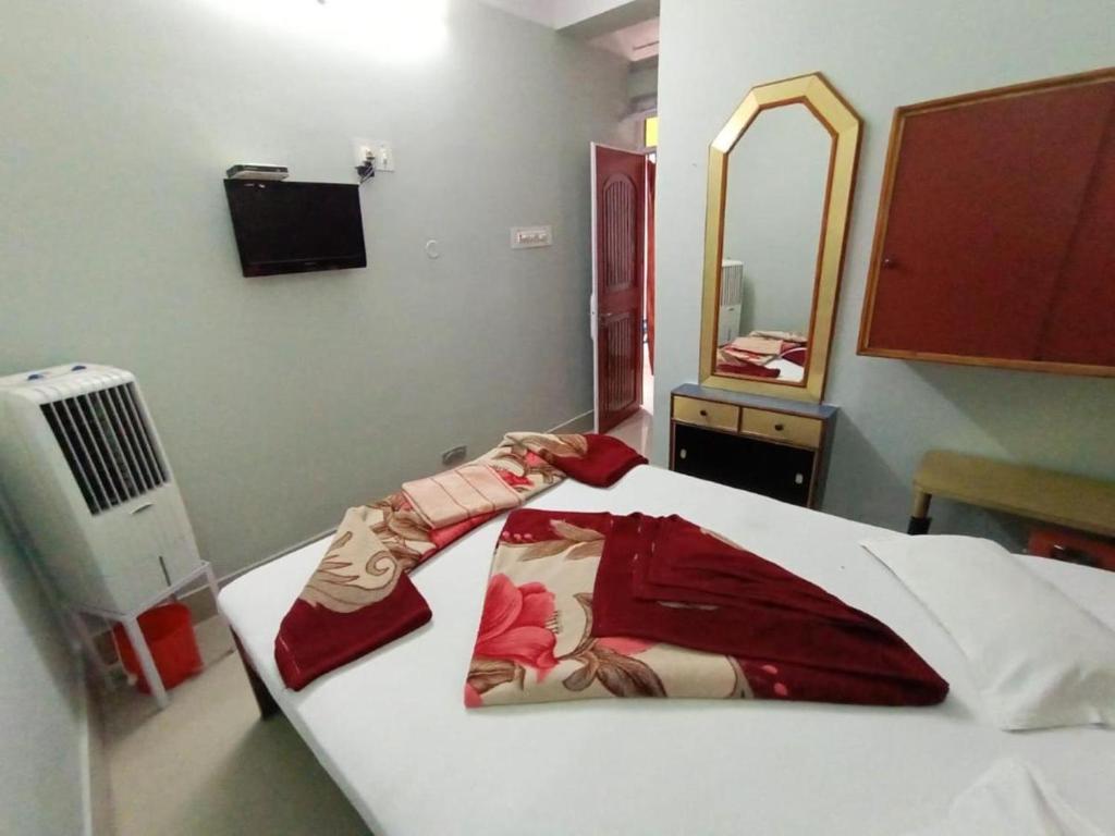 a bedroom with a bed with a robe and a mirror at Hotel swapanlok, Couple Friendly Hotel in Muzaffarpur