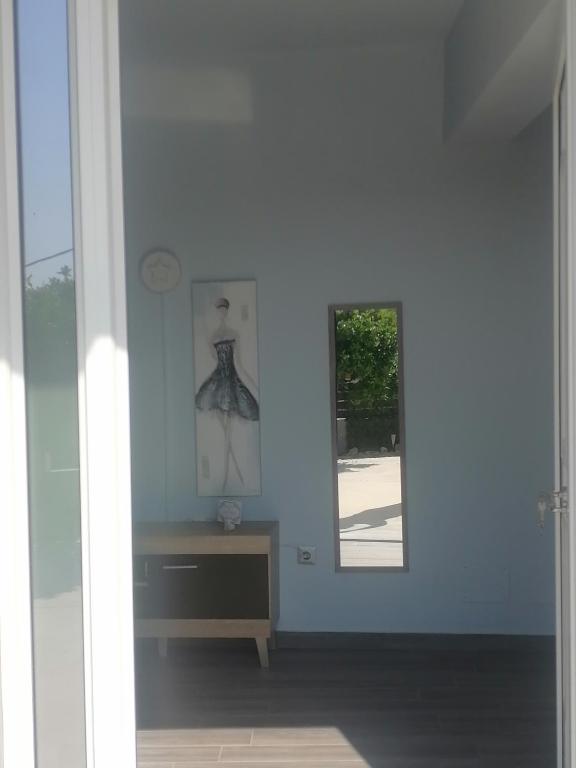 Dieses weiße Zimmer verfügt über ein Fenster und einen Tisch. in der Unterkunft casaeudokia in Apóllona