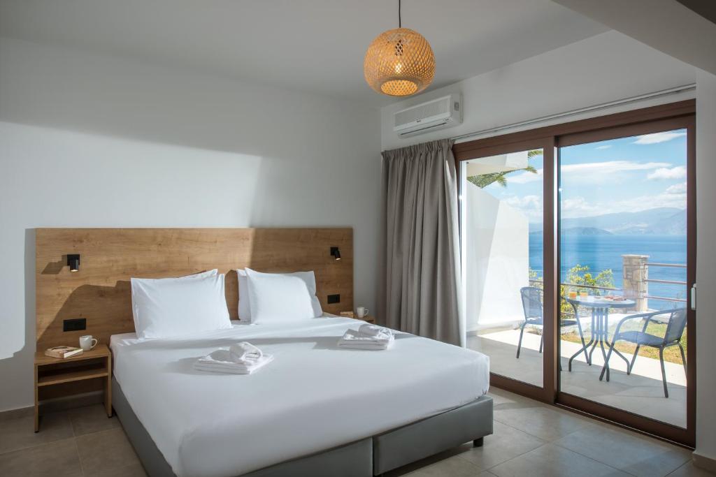1 dormitorio con cama y vistas al océano en Sunlight Elounda - Adults only Hotel "by Checkin" en Ágios Nikólaos