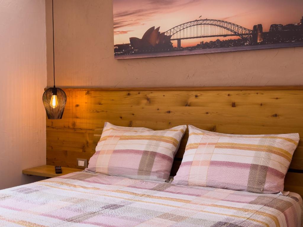 un letto con due cuscini e una foto sul muro di Appartamento Litegosa a Panchia