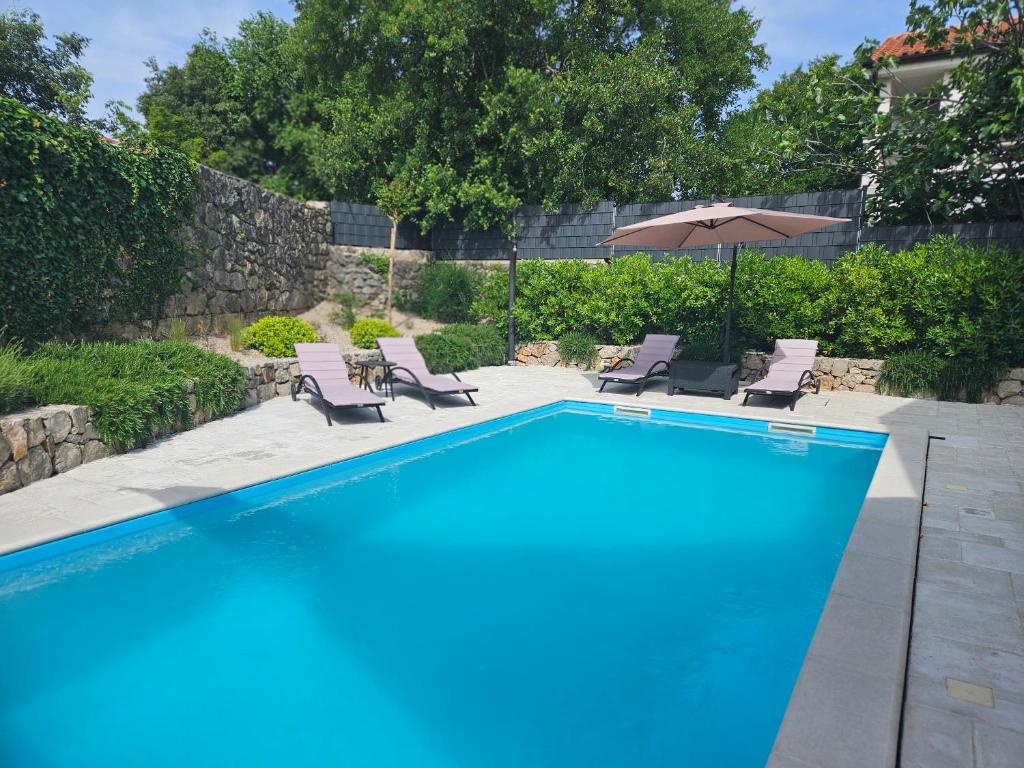 uma piscina com cadeiras e um guarda-sol em Villa Bellina Muraj em Kornic