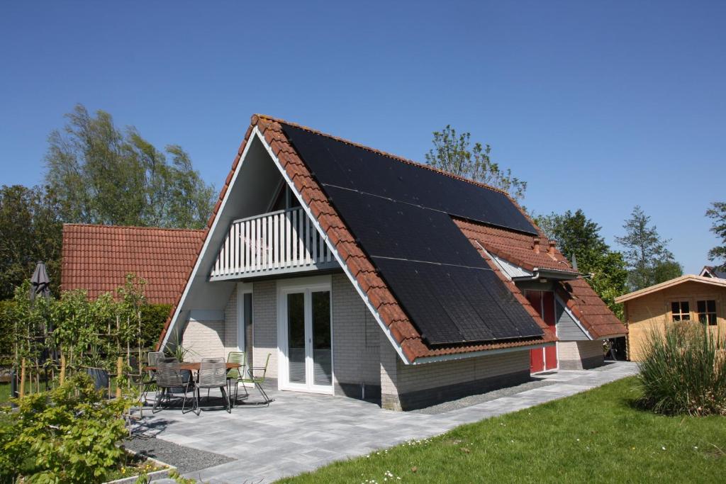 ein Haus mit Sonnenkollektoren auf dem Dach in der Unterkunft Schönes Ferienhaus in Oostmahorn (176) in Anjum