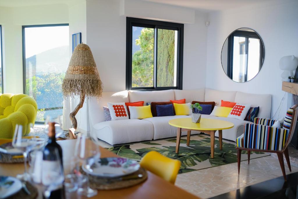 uma sala de estar com um sofá branco com almofadas coloridas em Villa d'exception vue mer avec piscine privée em Saint-Raphaël