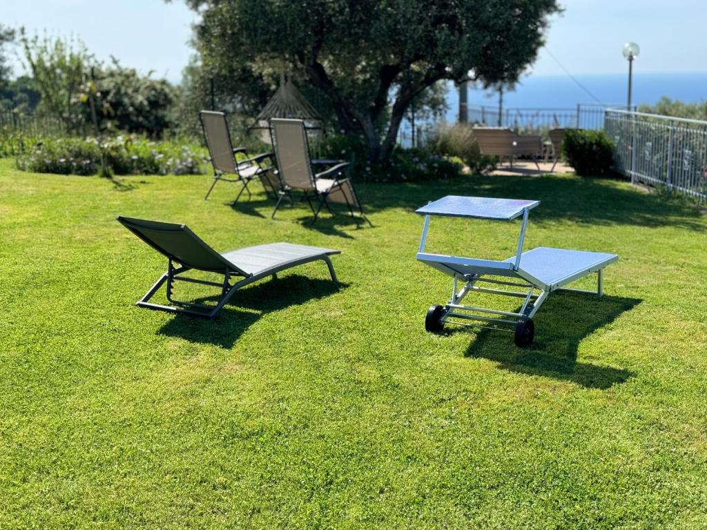 two chairs and a table in the grass at CASA VISTA MARE - Superb garden and Parking included in Imperia