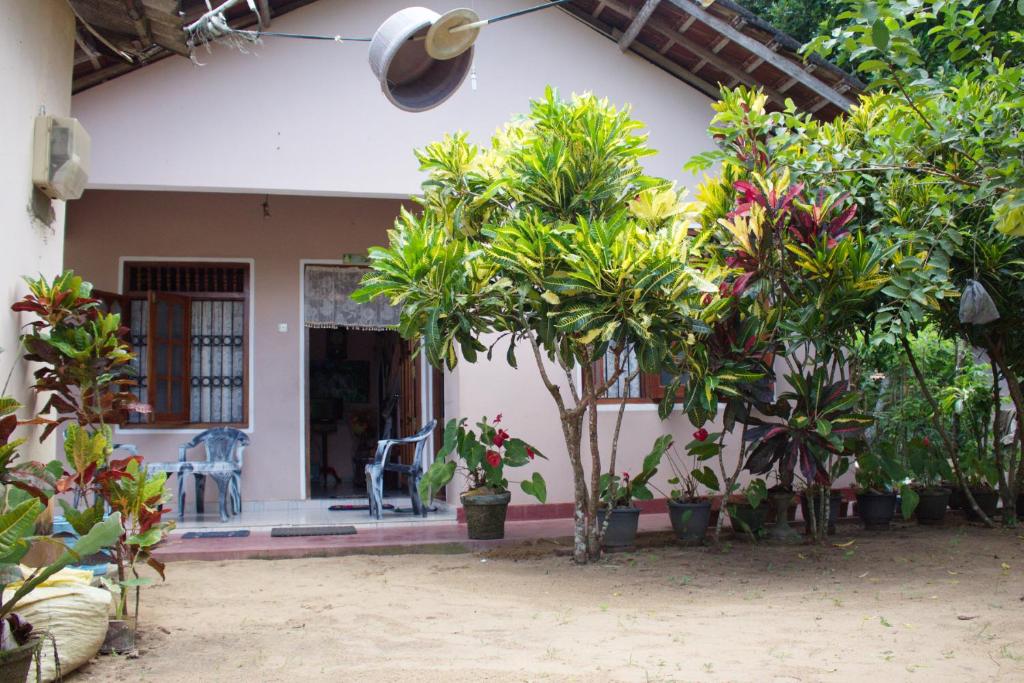 ein Haus mit Bäumen und Pflanzen davor in der Unterkunft Sagopearl Guest in Mirissa