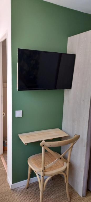 una scrivania con sedia e una TV a parete di Chambres d'hôtes Un Eté Sans Fin à 50 m de la plage à Canet plage a Canet-en-Roussillon