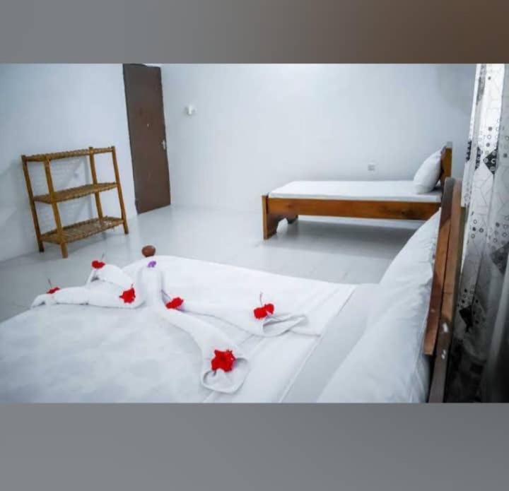 Un dormitorio con una cama con flores rojas. en BELLA VISTA homestay en Dimbani