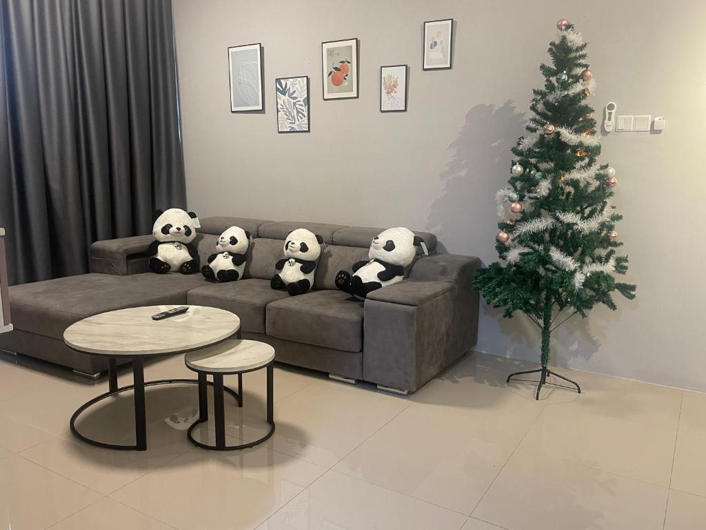a living room with a christmas tree and stuffed panda bears on a couch at IPOH TAMBUN THE COVE Your Ultimate Relaxation Getaway777 in Ipoh