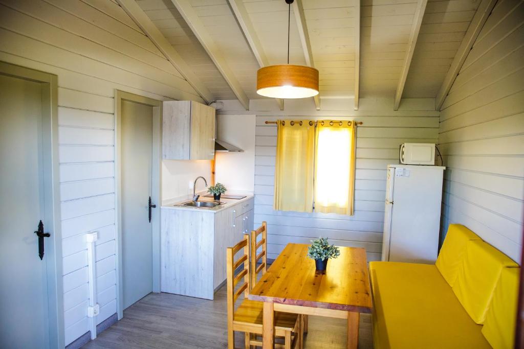 Camping La Llosa في كامبريلس: مطبخ وغرفة طعام مع طاولة وثلاجة