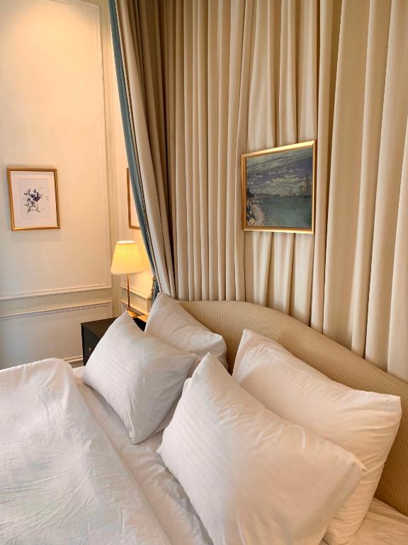 a bed with white pillows in a hotel room at The Atlantic Langkawi in Pantai Cenang