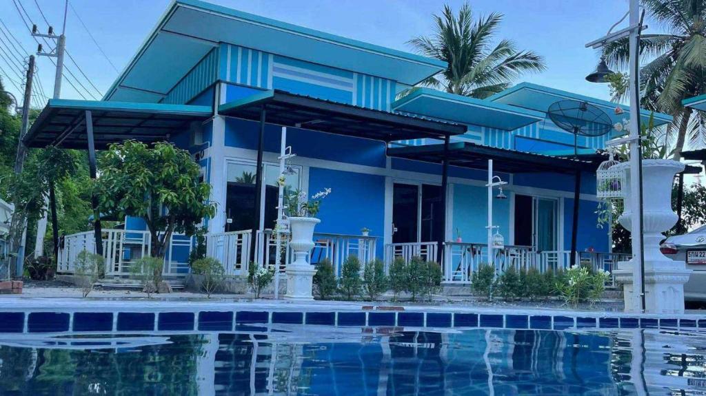 une maison bleue avec une piscine en face de celle-ci dans l'établissement Khao thalu guest house, à Ban Muang Wan