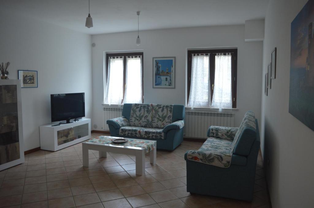uma sala de estar com duas cadeiras e uma televisão em Casa al Passaggio em Bettona