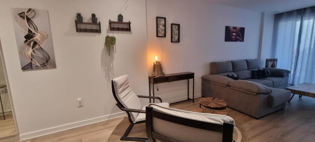 un salon avec un canapé, un fauteuil et une table dans l'établissement Appartement Penthouse Orihuela costa, à Orihuela Costa