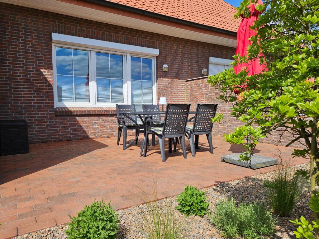a patio with black chairs and a table in front of a building at Stilvoll eingerichtetes Ferienhaus in ruhiger Lage in Bremerhaven