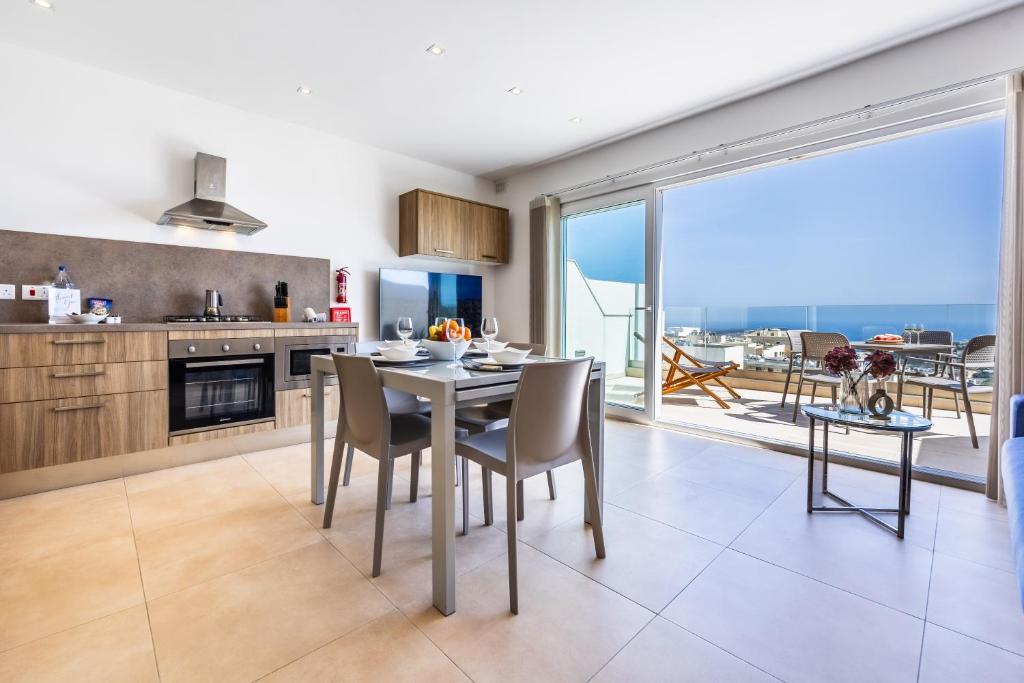 - une cuisine et une salle à manger avec une table et des chaises dans l'établissement Fl7 Thelodge-stunning Views With Spacious Terrace, à Mellieħa