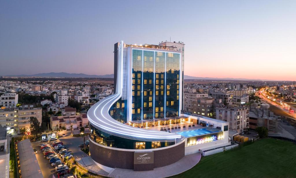 a tall building with a pool in front of a city at Concorde Tower Hotel & Casino in Lefkosa Turk