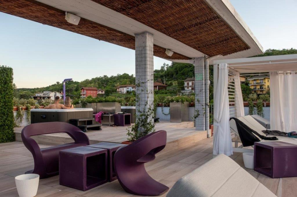 un patio con sillas moradas y una mesa en Hotel Le Palme en Dormelletto