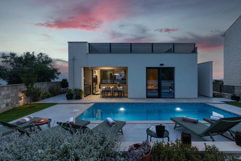 ドゥブロヴニクにあるLuxury Villa Ginaの夕暮れ時のスイミングプール付きのヴィラ