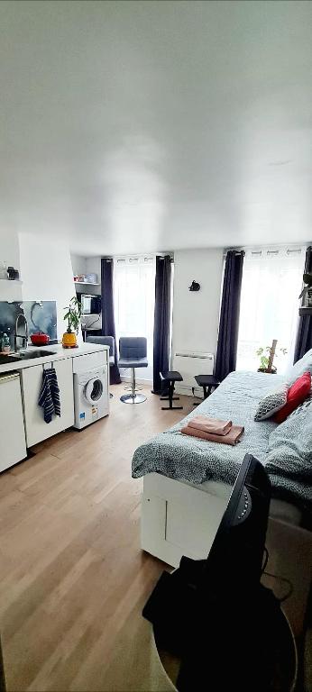 Cette chambre comprend un lit, un bureau et une cuisine. dans l'établissement Escale dans le haut Marais, à Paris