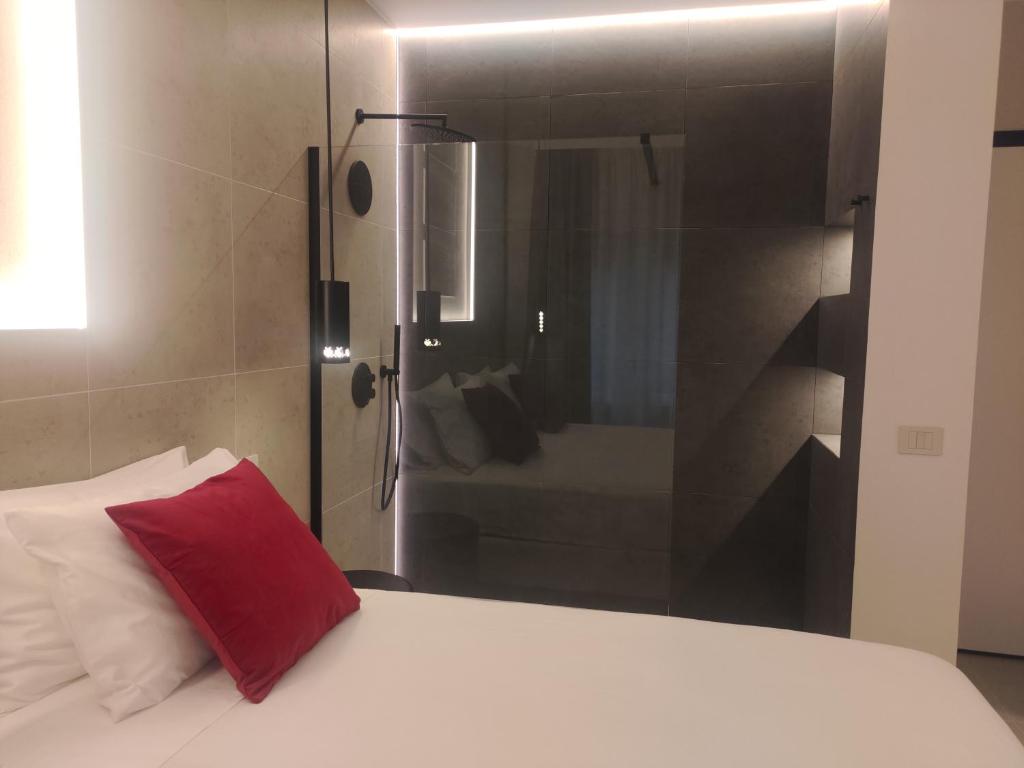 une chambre avec un lit avec un oreiller rouge dessus dans l'établissement Su Coru 2 - Deluxe Studio in the Heart of Cagliari, à Cagliari