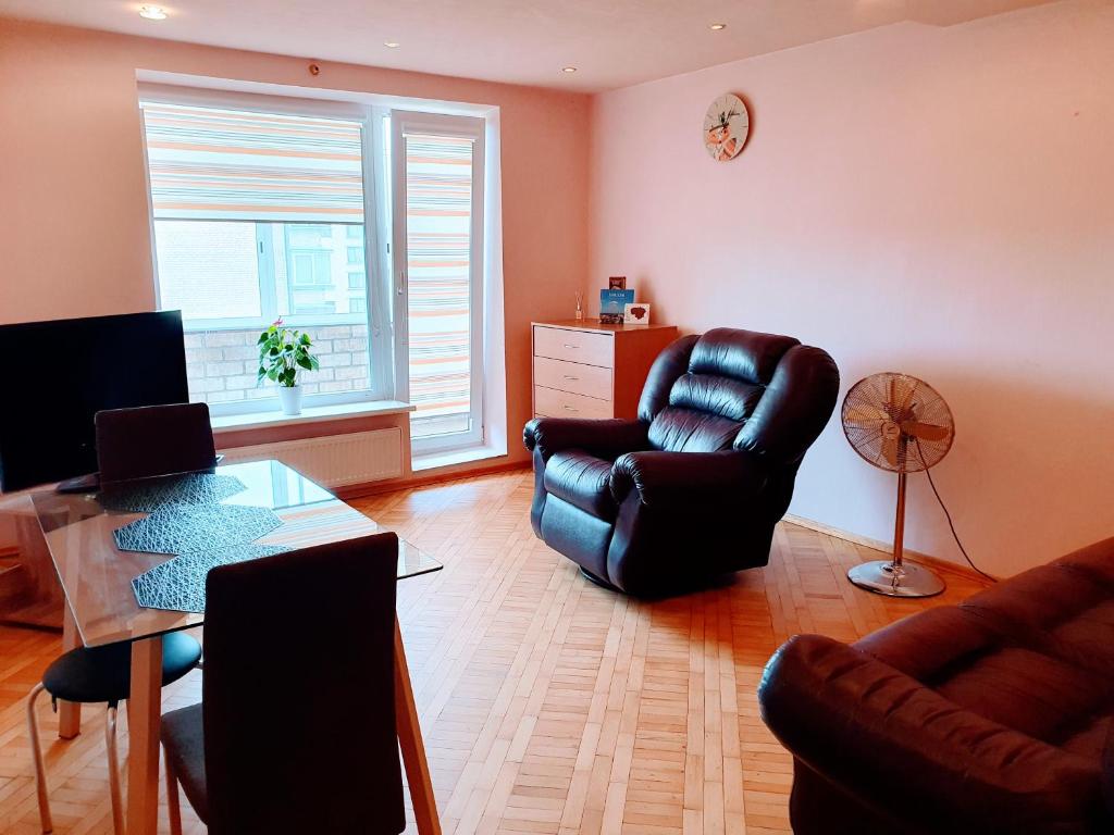 un soggiorno con tavolo e sedia in pelle di Apartments in the Sun CITY a Šiauliai