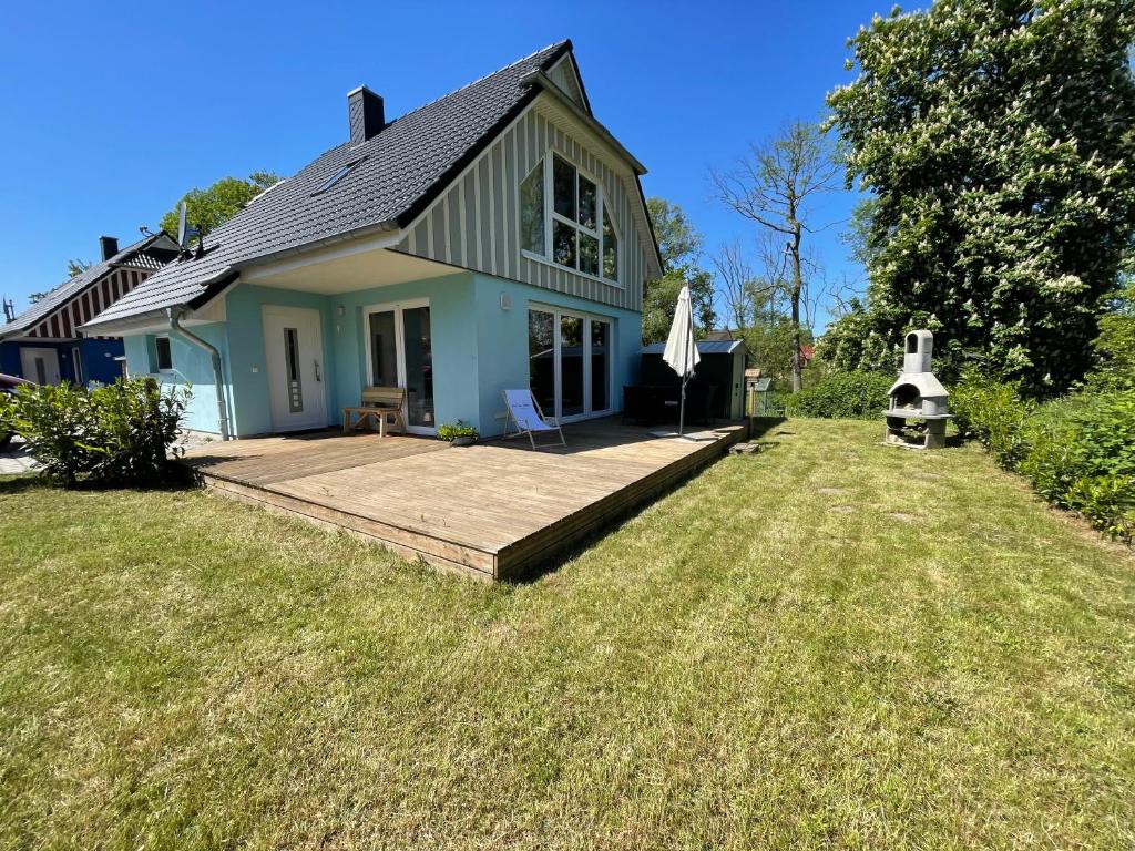 a house with a wooden deck in the yard at Ferienhaus am Nationalpark, Klausdorf, ca 250m bis zur Badestelle in Klausdorf Mecklenburg Vorpommern